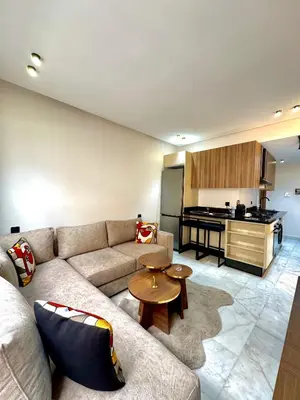 a living room with a couch and a kitchen at ARENA 41- Maarif in Casablanca