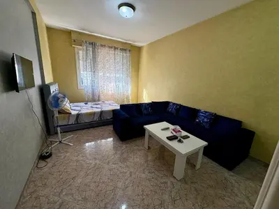 a living room with a blue couch and a table at Dar Raciki Elikya in Rabat