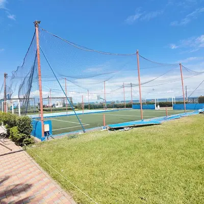 a tennis court with a net on a field at Appartement Tamaris avec piscine et plage privée in Casablanca