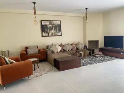 a living room with a couch and a flat screen tv at Magnifique Appartement Bahia Golf Beach in Bouznika