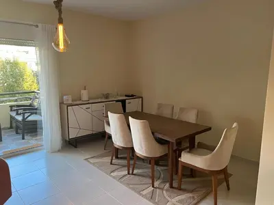 a dining room with a wooden table and chairs at Magnifique Appartement Bahia Golf Beach in Bouznika