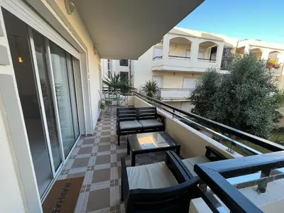 a balcony with chairs and tables on a building at Magnifique Appartement Bahia Golf Beach in Bouznika