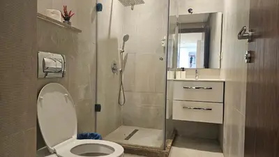 a bathroom with a shower with a toilet and a sink at Beautiful 3-Bedroom Apartment in Maarif, Spacious Living for Families, Groups & Business Travelers in Casablanca