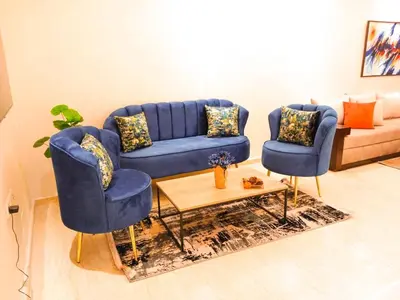 a living room with two blue chairs and a couch at Elegant Lateral Beachfront Family Stay in Casablanca