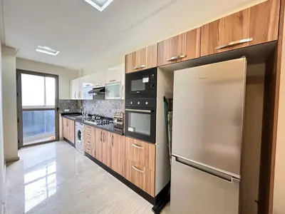 a kitchen with wooden cabinets and a stainless steel refrigerator at Elegant Lateral Beachfront Family Stay in Casablanca