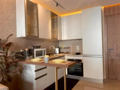 a kitchen with white cabinets and a wooden counter top at Rafina in Casablanca
