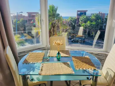a table with a vase on top of a window at Magnifique studio cosy et lumineux avec vue sur mer in Tamaris