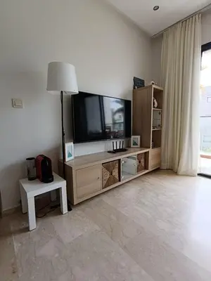 a living room with a large flat screen tv at GARDEN BAY Appartement Luxe Front de Mer à Tamaris Sidi Rahal, Plage Privée, Piscine et Loisirs in Tamaris
