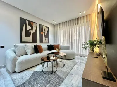 a living room with a couch and a table at Cosy Central Studio with balcony Maarif - Near Twin Center in Casablanca