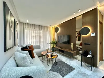 a living room with a couch and a tv at Cosy Central Studio with balcony Maarif - Near Twin Center in Casablanca