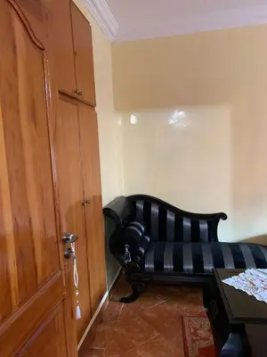 a black leather couch in a room with a door at Bouznika 100m2 Piscineplage in Bouznika