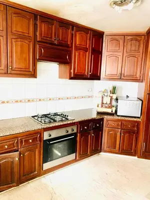 a kitchen with wooden cabinets and a stove top oven at Rabat Hay Riad 3 Ideal Rooms in Rabat