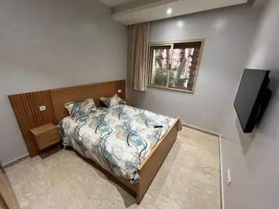 a bedroom with a bed and a television in it at Tamaris Green in Casablanca