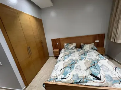 a bedroom with a bed and a wooden cabinet at Tamaris Green in Casablanca