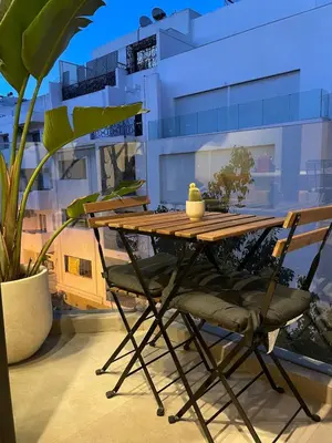 a wooden table and a chair sitting next to a building at NESK STAY Gauthier in Casablanca