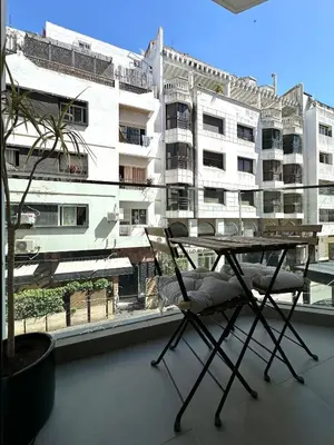 a table and chair on a balcony with a building at NESK STAY Gauthier in Casablanca