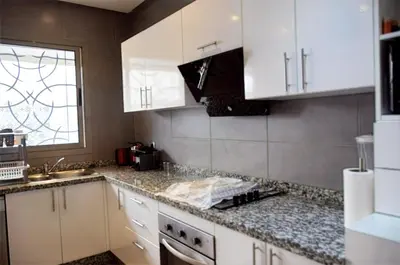 a kitchen with white cabinets and a sink and a window at Villa 130 Spacieuse 4 chambres dar bouazza proche plage in Casablanca