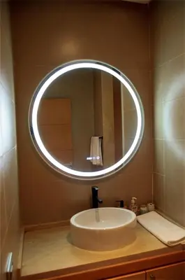 a bathroom sink with a large circular mirror on the wall at Villa 130 Spacieuse 4 chambres dar bouazza proche plage in Casablanca