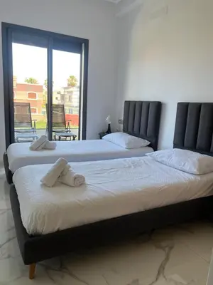 two beds sitting next to each other in a bedroom at Relaxing Stay 3 Pools & Beach in Sidi Rahal