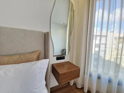a bedroom with a bed with a table next to a window at Cosy stylé et confortable in Casablanca