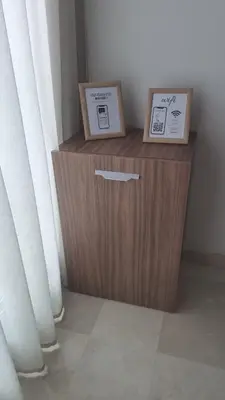 a wooden cabinet with two boxes on it next to a window at Cosy stylé et confortable in Casablanca