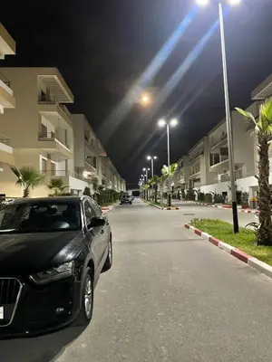 a black car parked on a street at night at Beautiful apartment with pool in Mansouria