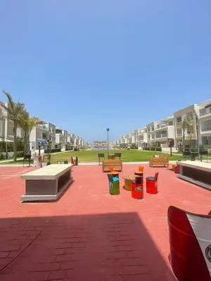 a park with colorful benches on a brick ground at Beautiful apartment with pool in Mansouria