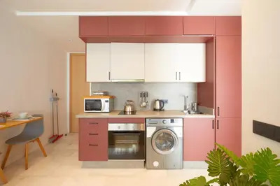 a kitchen with red cabinets and a washing machine at Beautiful 1 Bedroom in the Center of Casablanca in Casablanca