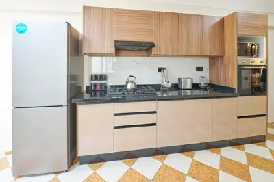 a kitchen with wooden cabinets and a white refrigerator at 3 Bedrooms and Room Balcony in Central Casablanca in Casablanca