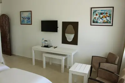 a room with a white table and a tv and a bed at Casa Palma Morocco in Sidi Yahia az Zaʼer