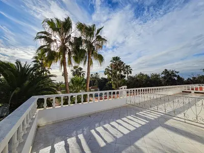 a white fence on a balcony with palm trees at Casa Palma Morocco in Sidi Yahia az Zaʼer