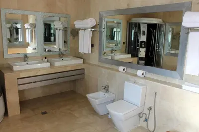 a bathroom with two sinks and a toilet and mirrors at Casa Palma Morocco in Sidi Yahia az Zaʼer
