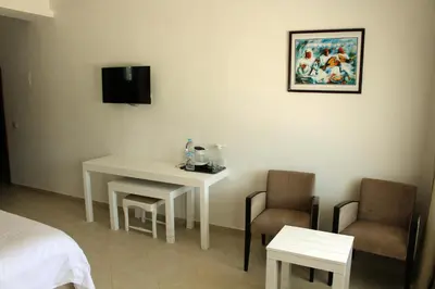 a room with a table and two chairs and a bed at Casa Palma Morocco in Sidi Yahia az Zaʼer