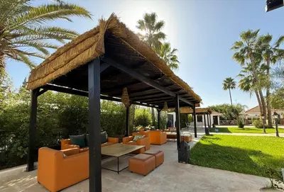 a gazebo with orange chairs and a table and chairs at Casa Palma Morocco in Sidi Yahia az Zaʼer