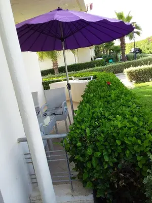 a purple umbrella on a patio with a table and chairs at Magnificent Luxury Beach Villa in Savannah Beach in Dar Hamida