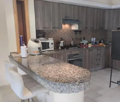 a kitchen with a granite counter top with a microwave at Magnificent Luxury Beach Villa in Savannah Beach in Dar Hamida