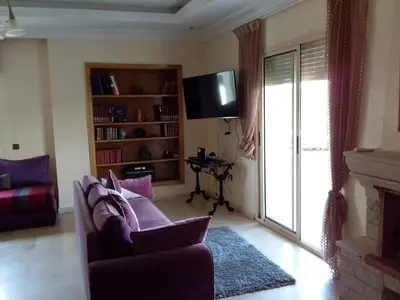 a living room with a couch and a tv at Magnificent Luxury Beach Villa in Savannah Beach in Dar Hamida
