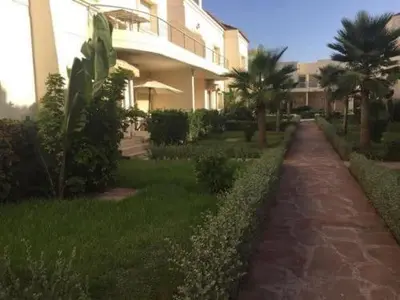 a walkway in front of a building with palm trees at Magnificent Luxury Beach Villa in Savannah Beach in Dar Hamida