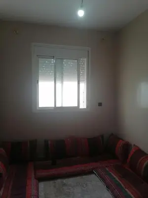 a living room with a couch and a window at 50m RDC aliace darna louizia in Mohammedia