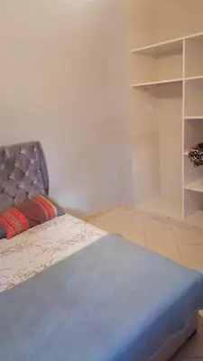 a bedroom with a bed and a book shelf at 50m RDC aliace darna louizia in Mohammedia