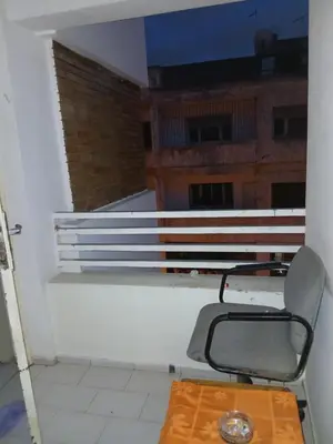 a chair and a table in a room at Maison agdal 2 chambres salon in Rabat
