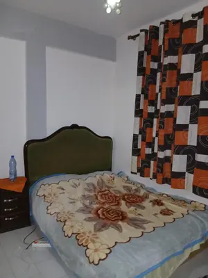 a bedroom with a bed with a flower blanket on it at Maison agdal 2 chambres salon in Rabat