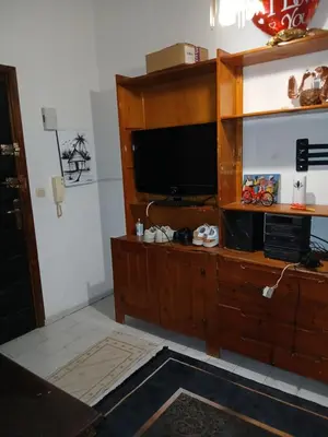 a large wooden entertainment center with a flat screen tv at Maison agdal 2 chambres salon in Rabat