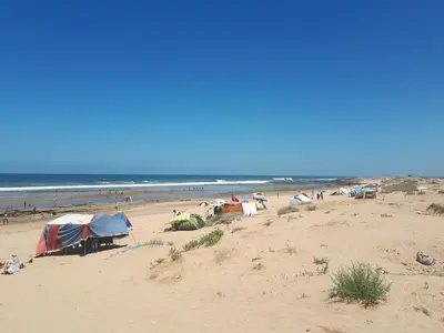 a group of tents on a beach near the ocean at Sunny modern Apartment- Ocean & Pool view in Al Mansouria in Mansouria
