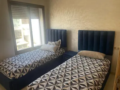 two beds sitting next to each other in a room at Sunny modern Apartment- Ocean & Pool view in Al Mansouria in Mansouria