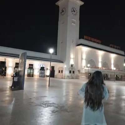 a girl standing in front of a building with a clock tower at Residence Les jardins de Belvedere in Casablanca