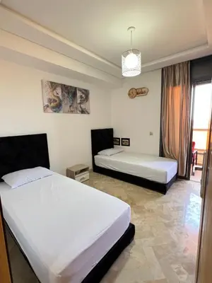 a bedroom with two beds and a window at Sweethome in Bouznika