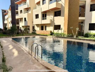 a swimming pool in front of a building at Sweethome in Bouznika