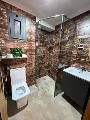 a bathroom with a toilet and a shower and a sink at Sweethome in Bouznika