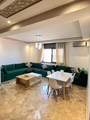 a living room with a green couch and a table at Sweethome in Bouznika